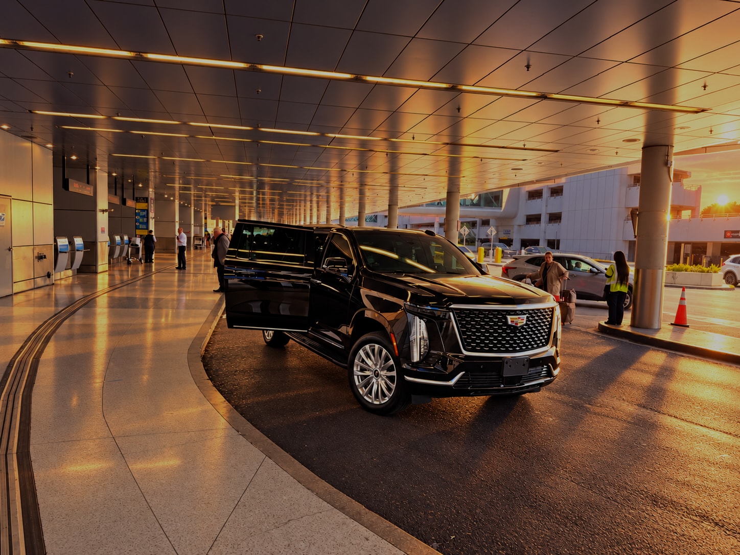 Black Cadillac Escalade parked at the airport terminal curbside