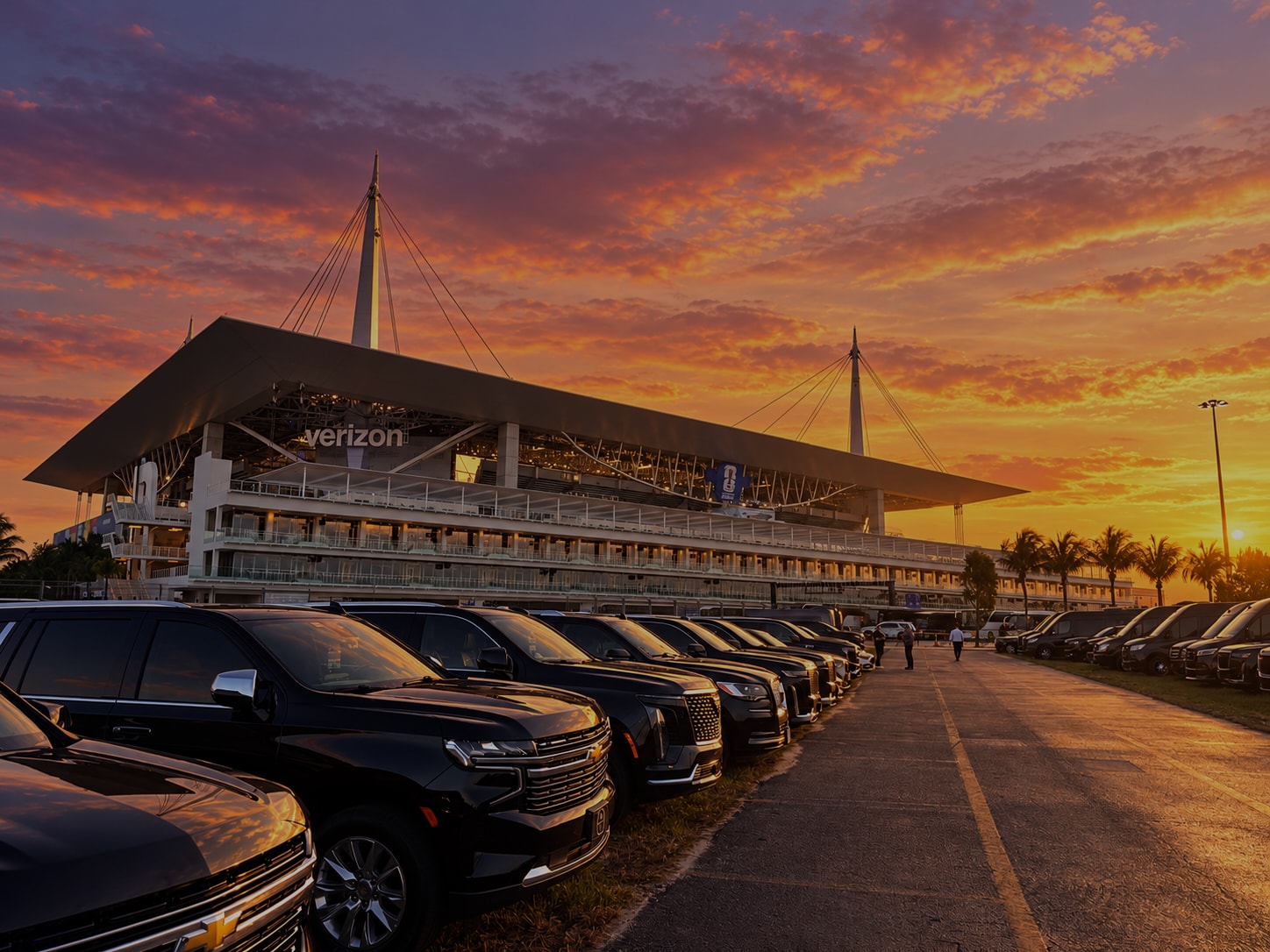 Row of black luxury SUVs lined up outside the Miami speedway grandstand